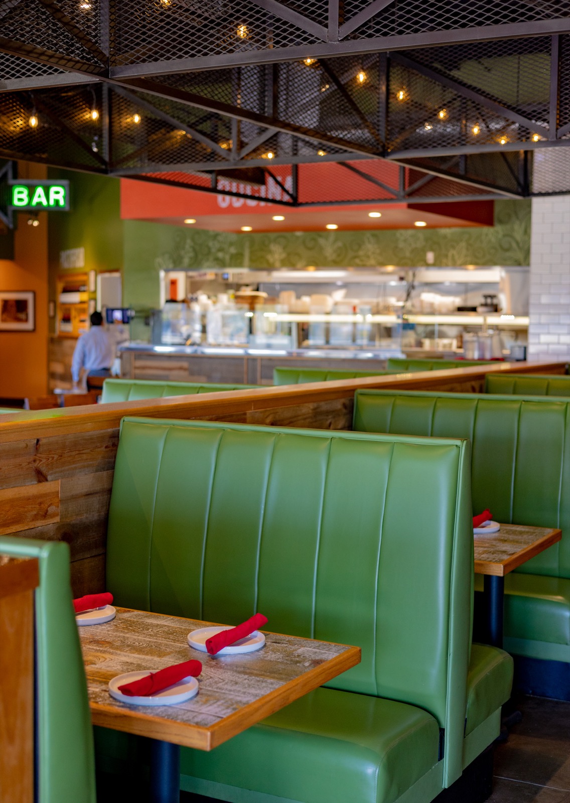 Green booths and warm lights inside Taglia Fresh Italian