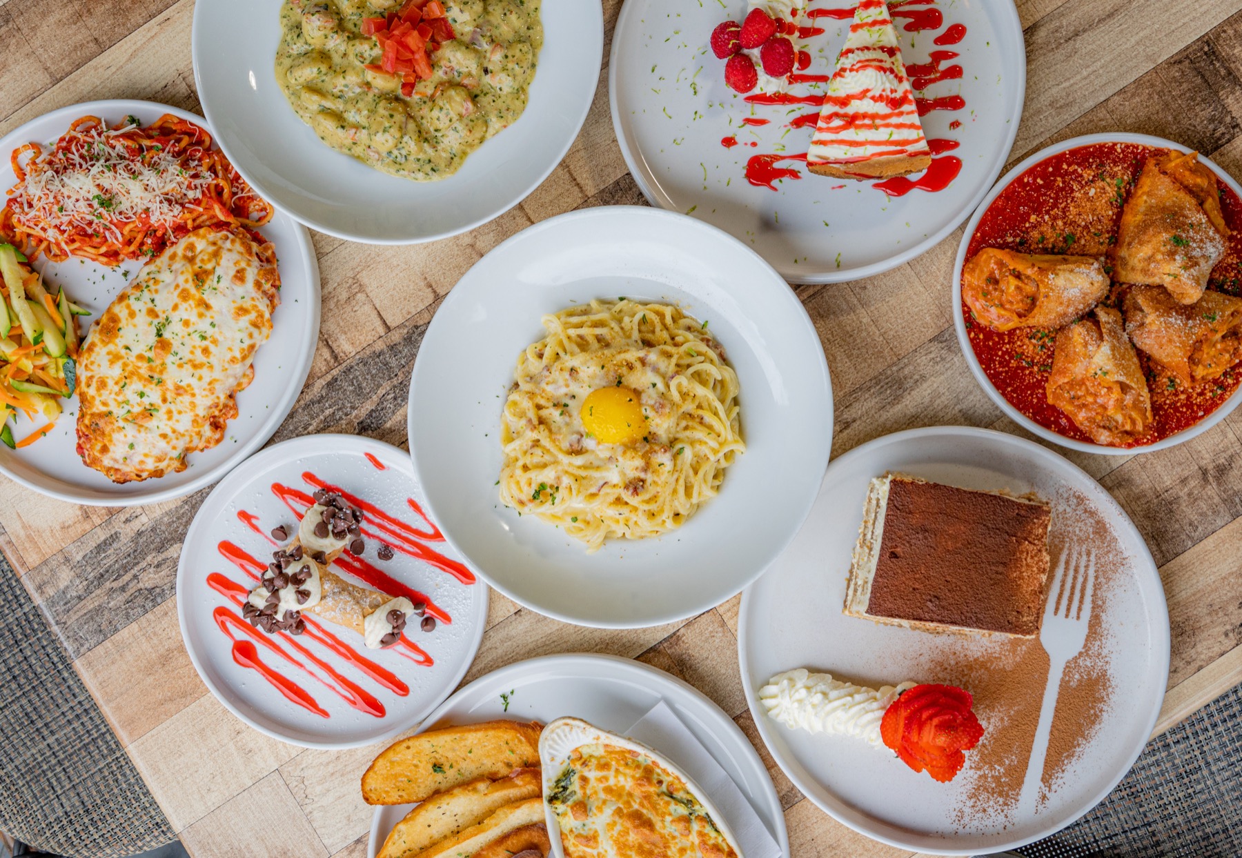 Overhead spread of Taglia pasta, entrees, and desserts